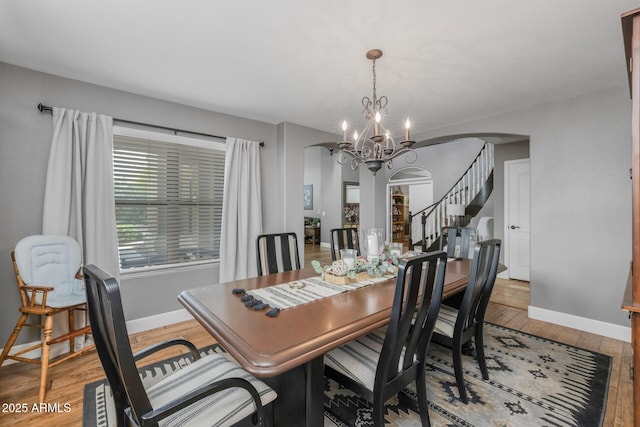 9708 E Pampa Ave, Mesa, AZ 85212 - dining space featuring arched walkways, a chandelier, wood finished floors, and baseboards