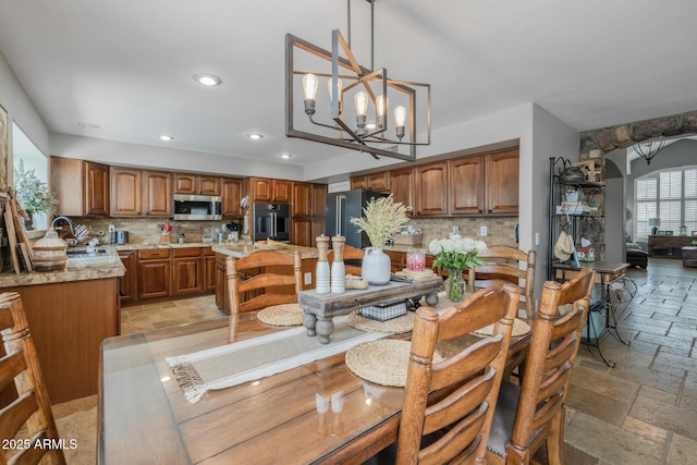 9708 E Pampa Ave, Mesa, AZ 85212 - dining space featuring stone tile flooring, recessed lighting, a chandelier, and arched walkways
