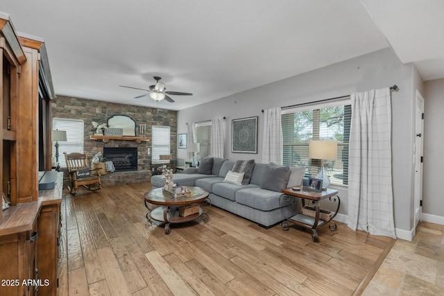 9708 E Pampa Ave, Mesa, AZ 85212 - living room with a stone fireplace, a ceiling fan, hardwood / wood-style flooring, and baseboards