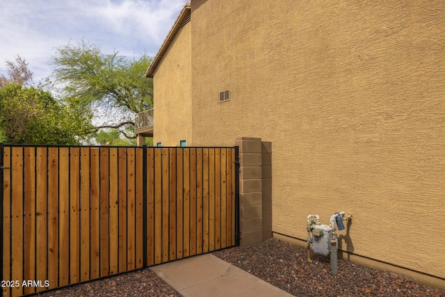 9708 E Pampa Ave, Mesa, AZ 85212 - view of side of property featuring a gate, stucco siding, fence, and a balcony