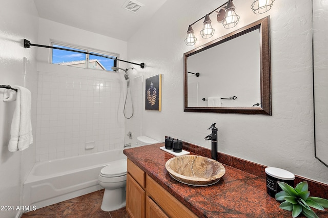 full bathroom with tile patterned floors, vanity, tiled shower / bath, and toilet