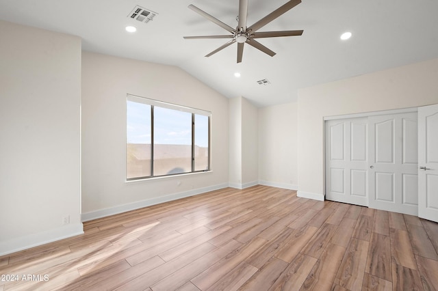 unfurnished bedroom featuring a closet, ceiling fan, light hardwood / wood-style flooring, and lofted ceiling