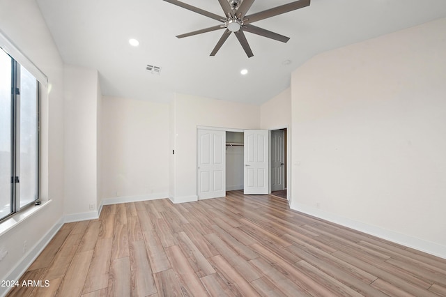 unfurnished bedroom with ceiling fan, light hardwood / wood-style floors, a closet, and vaulted ceiling