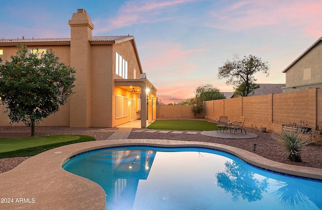 pool at dusk featuring a patio