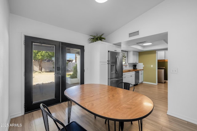 dining space featuring light wood-style floors, french doors, baseboards, washer / dryer, and visible vents