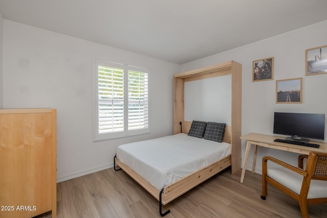 bedroom with baseboards and light wood finished floors