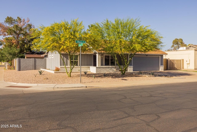 view of front of home with fence, concrete driveway, and a garage