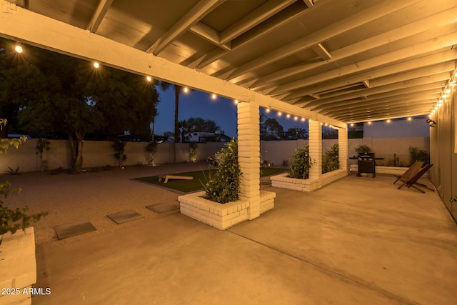 patio at night with a fenced backyard