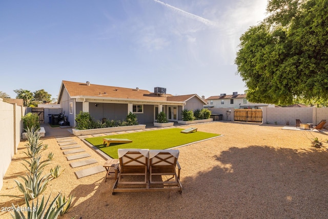 back of house featuring central AC unit, a gate, a fenced backyard, a yard, and a patio