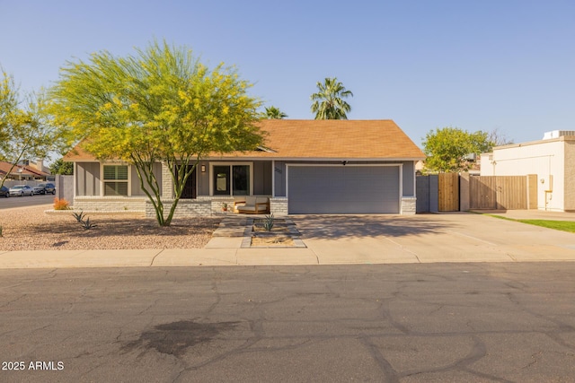 view of front facade with a garage, fence, and concrete driveway