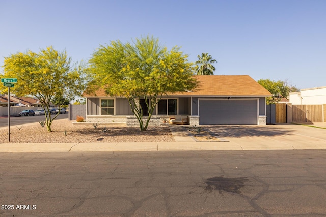 view of front facade with fence, an attached garage, and concrete driveway