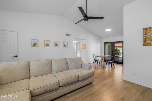 living area featuring high vaulted ceiling, french doors, a ceiling fan, light wood-type flooring, and visible vents