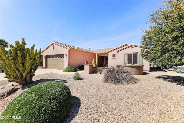 mediterranean / spanish house featuring a tiled roof, an attached garage, driveway, and stucco siding