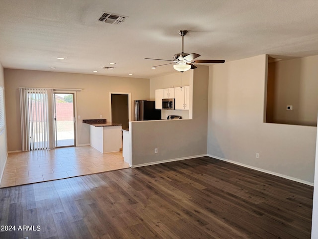 unfurnished living room featuring hardwood / wood-style flooring and ceiling fan