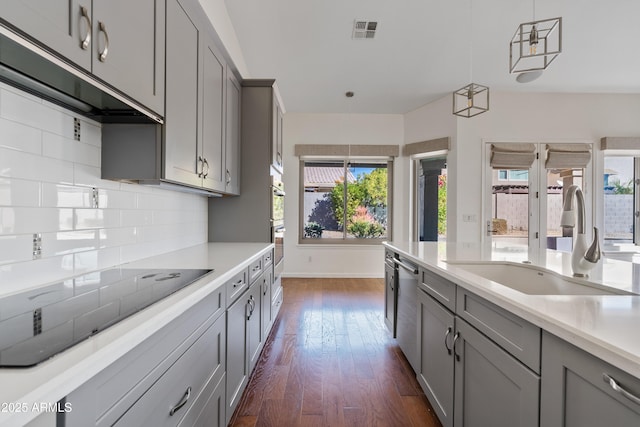 kitchen featuring gray cabinetry, sink, pendant lighting, and appliances with stainless steel finishes