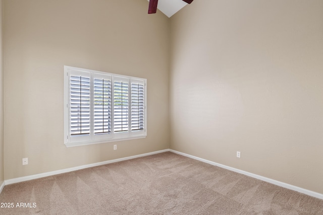 carpeted empty room featuring high vaulted ceiling and ceiling fan