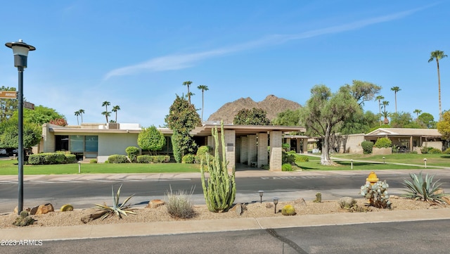 exterior space featuring a mountain view and a front lawn