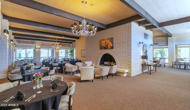 dining space with beam ceiling, brick wall, and carpet floors