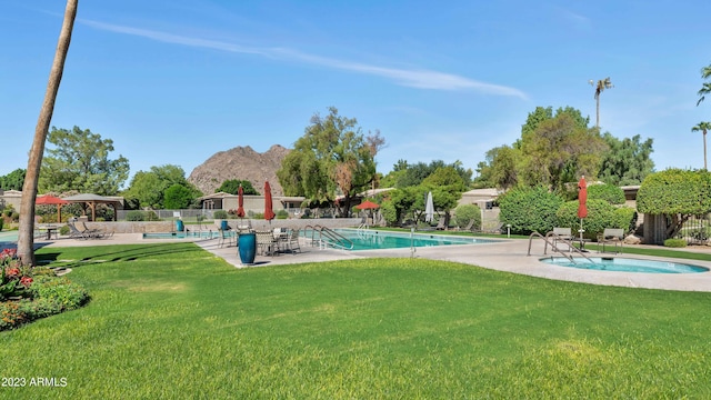 view of swimming pool with a yard, a patio, and a hot tub