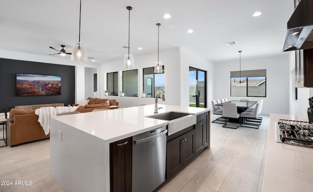 kitchen with extractor fan, an island with sink, hanging light fixtures, sink, and appliances with stainless steel finishes