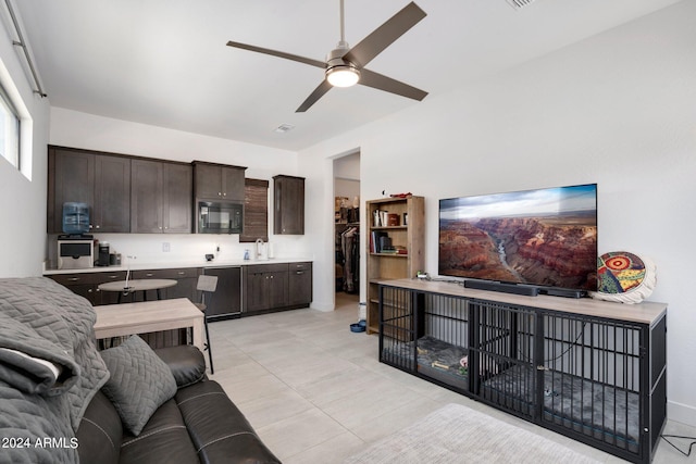 living area with light tile patterned floors, baseboards, and ceiling fan