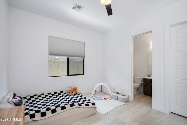 bedroom featuring ensuite bath, light tile patterned floors, and ceiling fan