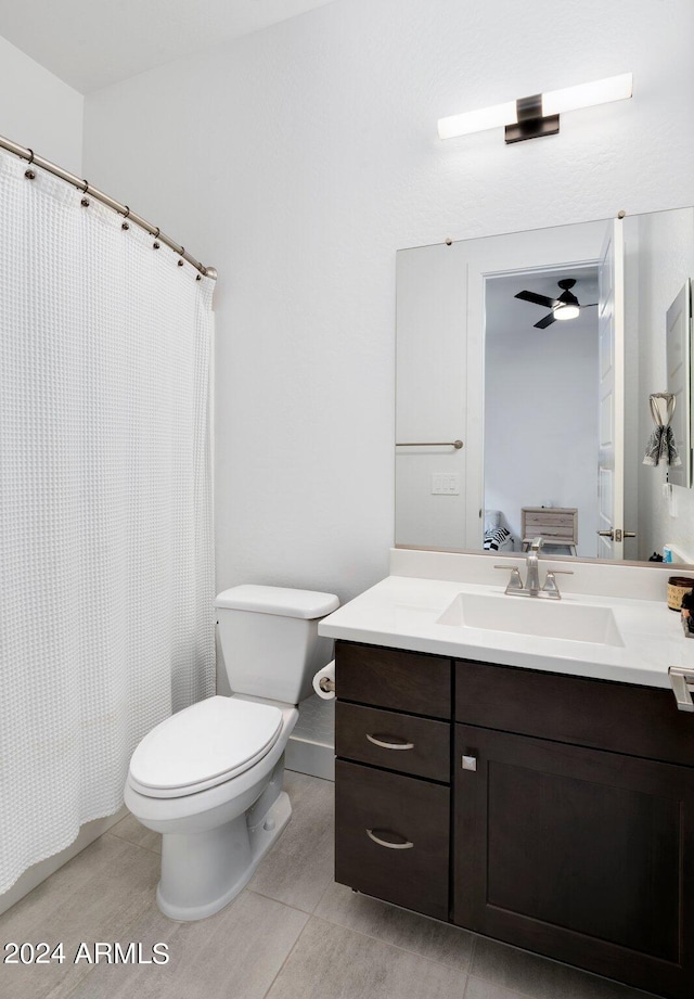 bathroom with a shower with shower curtain, toilet, ceiling fan, tile patterned floors, and vanity