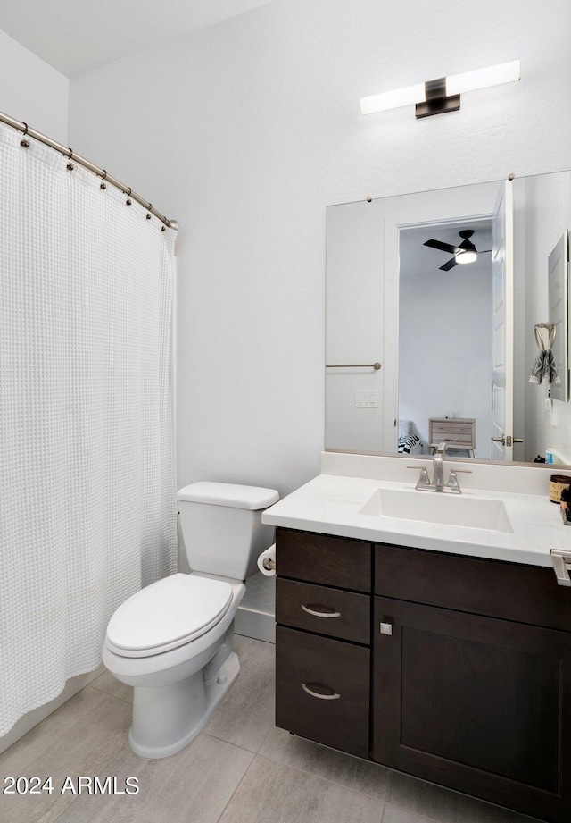 ensuite bathroom featuring connected bathroom, ceiling fan, tile patterned flooring, vanity, and toilet