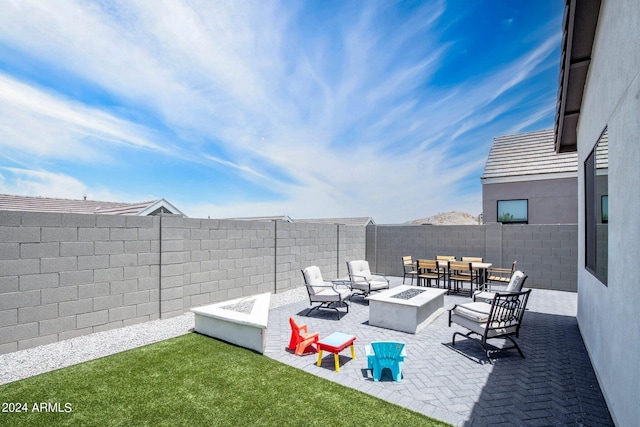 view of patio / terrace with a fenced backyard and an outdoor living space with a fire pit