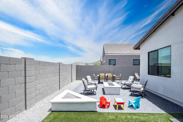 view of patio featuring a fenced backyard and an outdoor living space with a fire pit