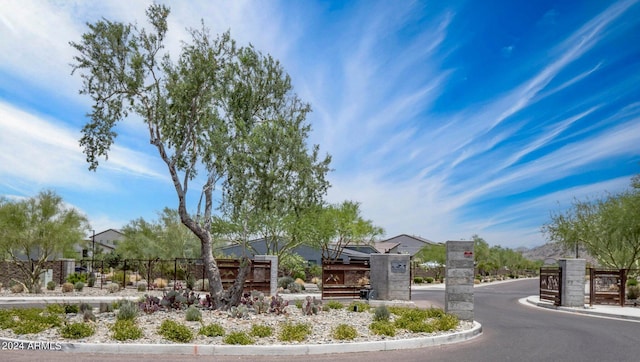 community / neighborhood sign featuring fence and a residential view