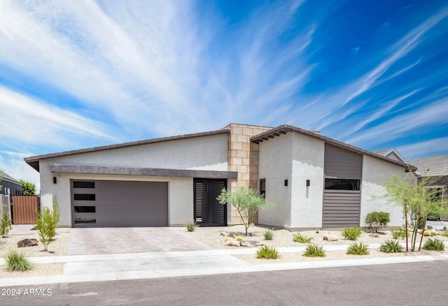 view of front of house featuring fence, a garage, driveway, and stucco siding