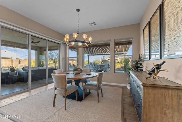 dining area with light wood-type flooring and an inviting chandelier