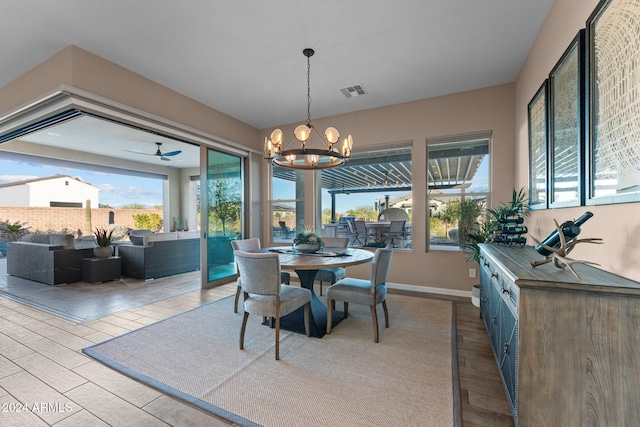 dining space featuring light hardwood / wood-style floors and ceiling fan with notable chandelier