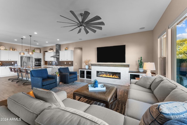 living room with light hardwood / wood-style flooring and ceiling fan