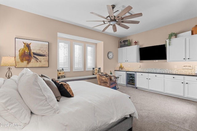 bedroom with beverage cooler, light carpet, and ceiling fan