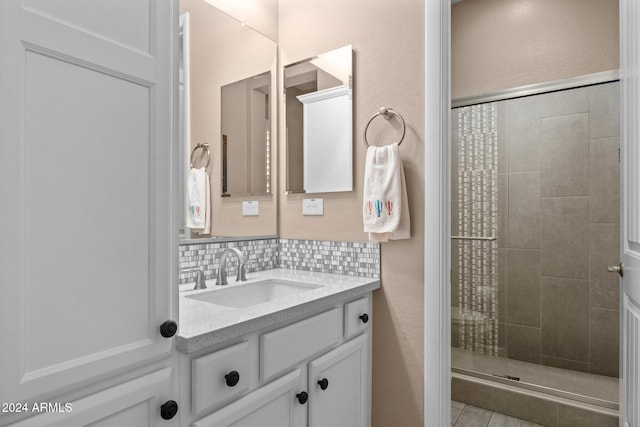 bathroom with tasteful backsplash, vanity, and tiled shower