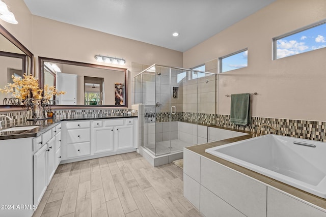 bathroom with a wealth of natural light, vanity, hardwood / wood-style flooring, and independent shower and bath