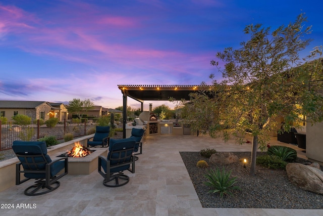 patio terrace at dusk with area for grilling and an outdoor fire pit