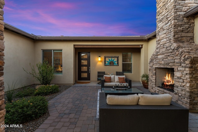 patio terrace at dusk featuring an outdoor living space with a fireplace