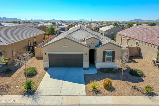 ranch-style home with a residential view, concrete driveway, and stucco siding