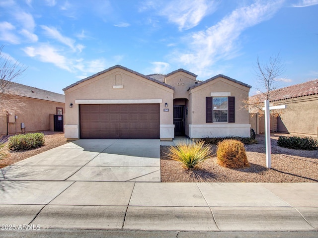 mediterranean / spanish home featuring concrete driveway, a tile roof, an attached garage, fence, and stucco siding