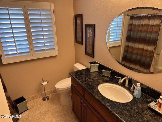 bathroom featuring toilet, vanity, and tile patterned floors