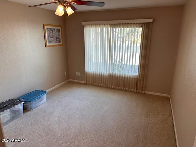 spare room with light carpet and ceiling fan