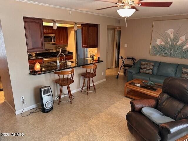 living room with crown molding, sink, and ceiling fan