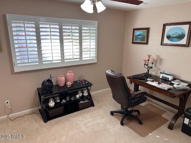 carpeted office space featuring ceiling fan