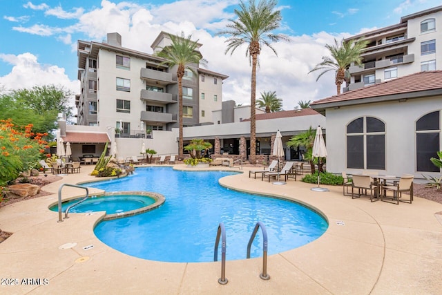 view of pool featuring a pool with connected hot tub and a patio