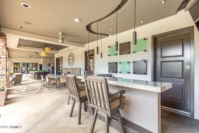 kitchen featuring a ceiling fan, concrete floors, recessed lighting, light countertops, and open floor plan