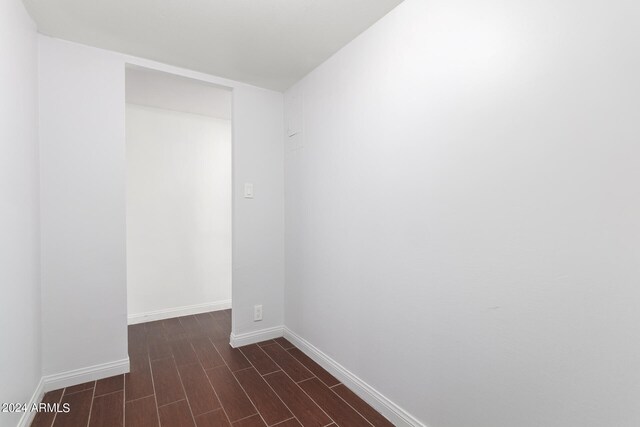 unfurnished room with dark wood-type flooring