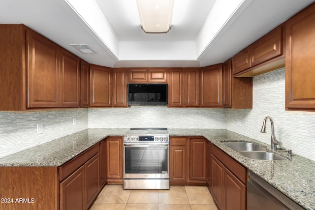 kitchen with light stone counters, sink, stainless steel appliances, a raised ceiling, and light tile patterned floors